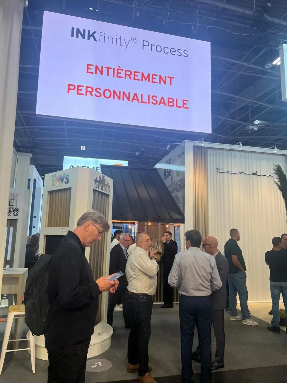 Échanges entre visiteurs sur un stand du salon